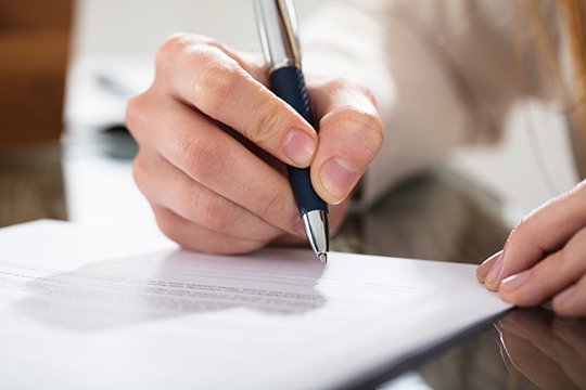Business owner signing a managed services contract for OKI Data toner and printer supplies